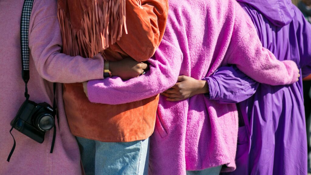 four person holding each others waist at daytime